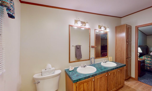 bathroom featuring vanity, toilet, wood-type flooring, and crown molding