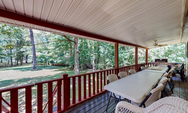 wooden deck featuring a lawn and ceiling fan