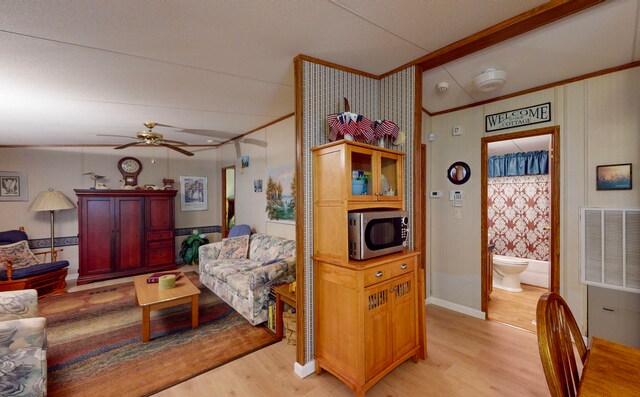 living room with ceiling fan, light hardwood / wood-style floors, and ornamental molding