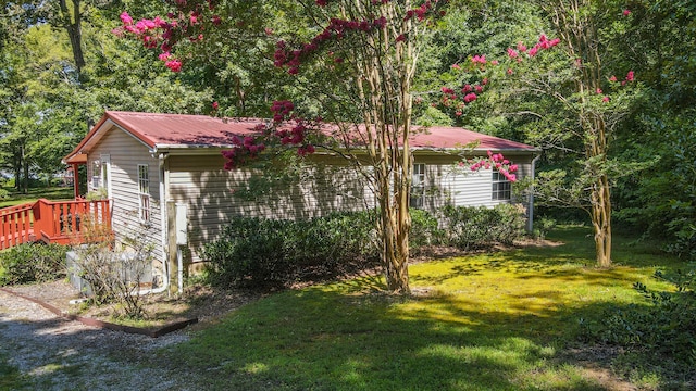 view of side of property with a yard and a deck