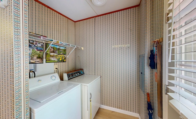 laundry room with washing machine and dryer, crown molding, and wood-type flooring