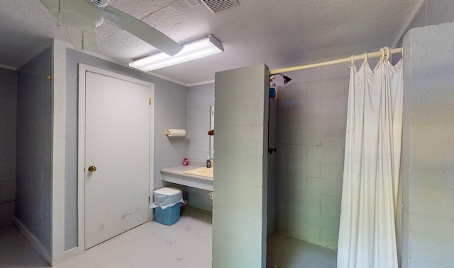 bathroom featuring a shower with curtain, concrete flooring, and a textured ceiling