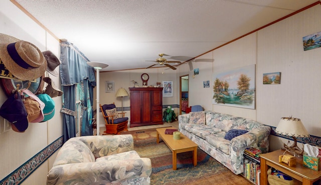 living room featuring ceiling fan, carpet floors, and a textured ceiling