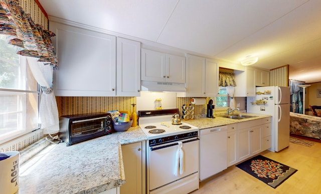 kitchen with white cabinetry, sink, light stone counters, and white appliances