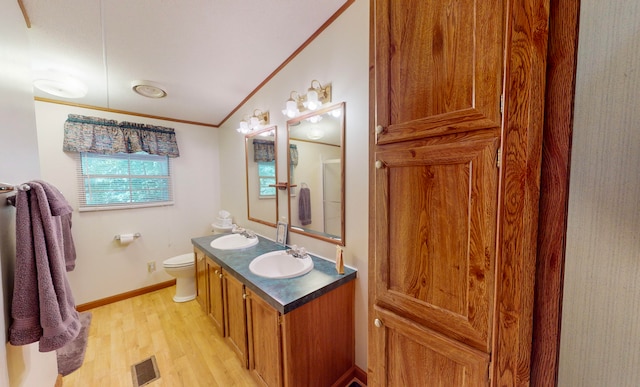 bathroom featuring crown molding, wood-type flooring, vaulted ceiling, toilet, and vanity