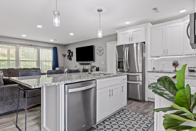 kitchen with white cabinets, stainless steel appliances, dark hardwood / wood-style floors, and sink