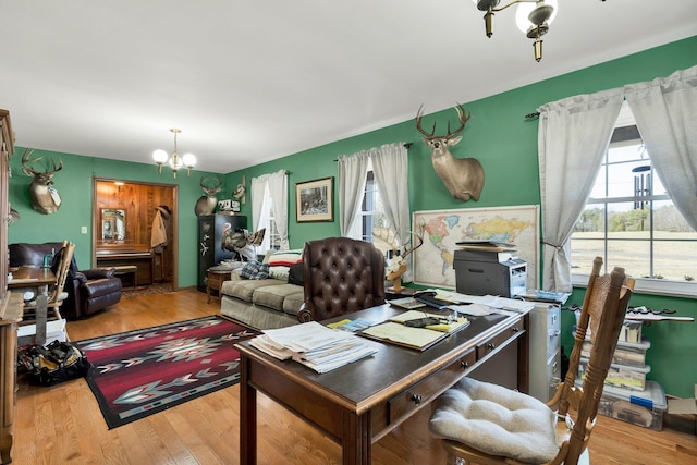 office space featuring an inviting chandelier and light hardwood / wood-style floors