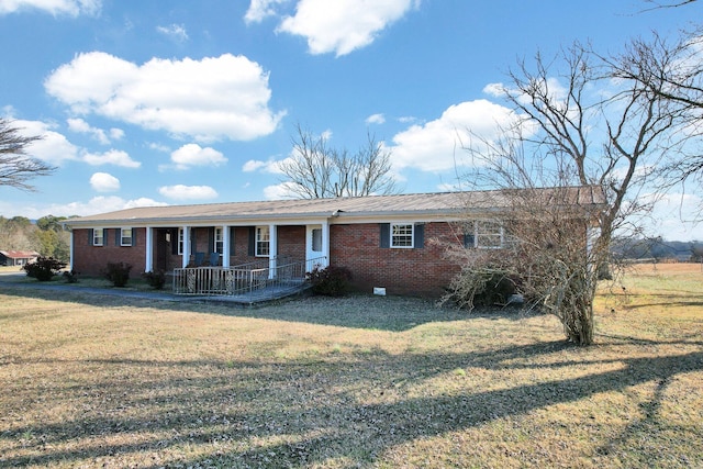 ranch-style home featuring a front lawn and covered porch