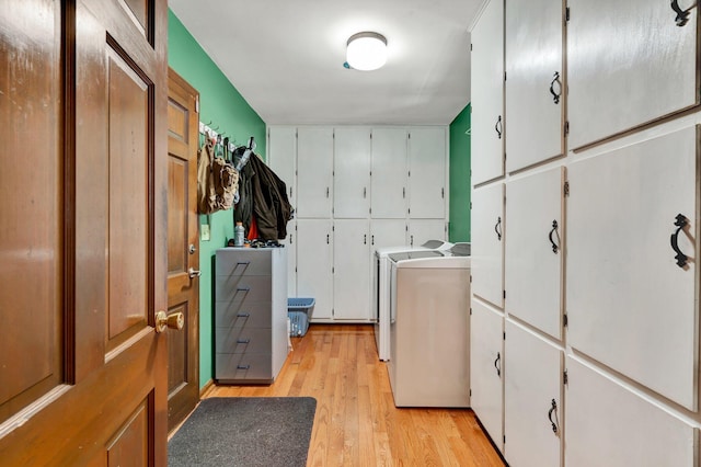 washroom featuring cabinets, separate washer and dryer, and light wood-type flooring