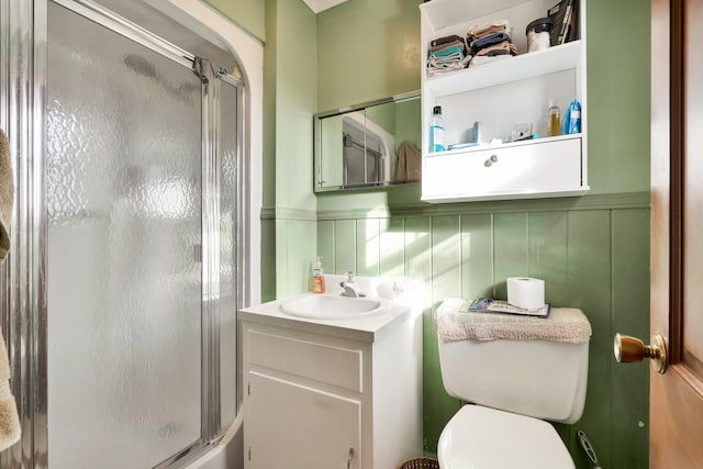 bathroom featuring vanity, toilet, backsplash, and a shower with shower door