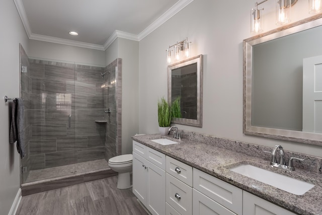 bathroom with toilet, crown molding, a sink, and a shower stall