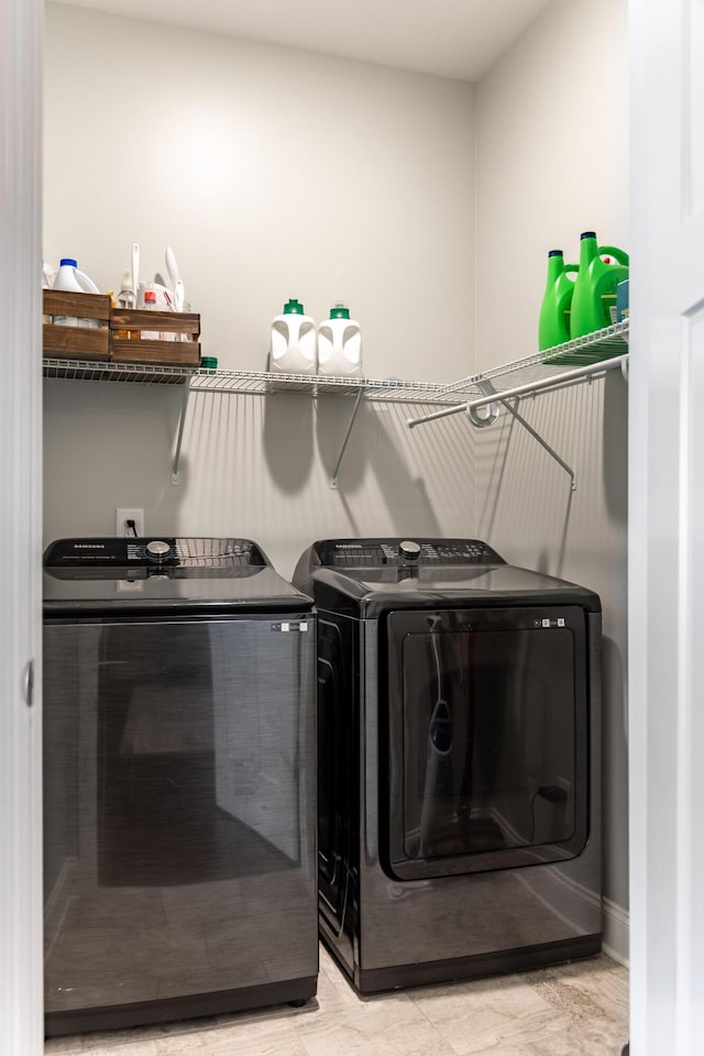 laundry room with laundry area, independent washer and dryer, and baseboards