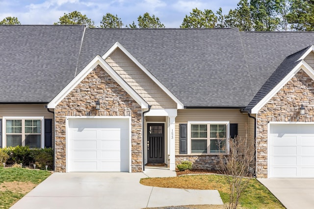 craftsman-style house featuring driveway, a shingled roof, and an attached garage