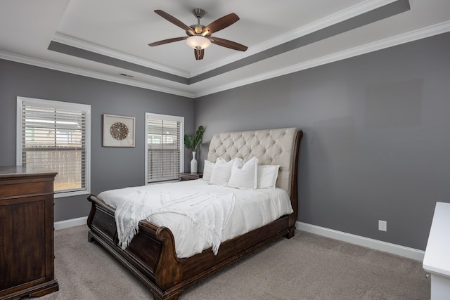 bedroom featuring light carpet, baseboards, visible vents, a tray ceiling, and crown molding