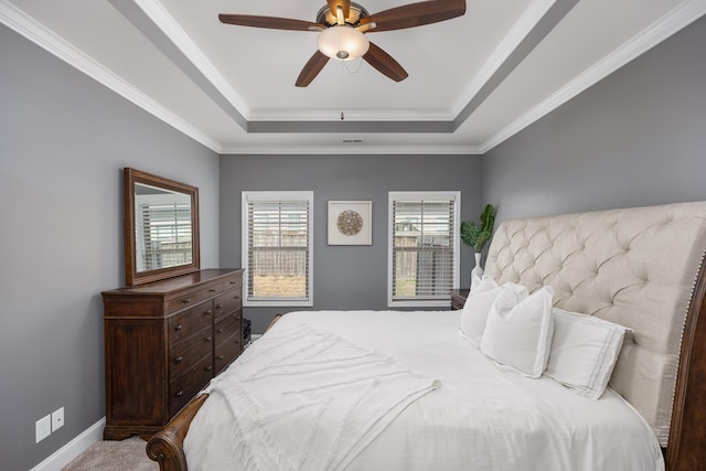 bedroom featuring a ceiling fan, baseboards, a tray ceiling, and crown molding