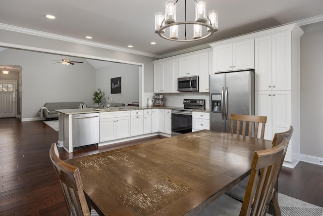 kitchen with decorative backsplash, dark wood-style flooring, a peninsula, stainless steel appliances, and white cabinetry