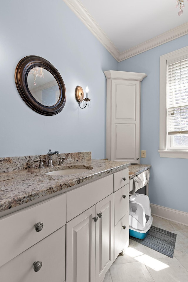 bathroom featuring vanity, tile patterned floors, baseboards, and ornamental molding