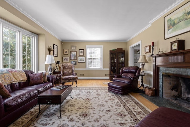 living room with a premium fireplace, ornamental molding, a baseboard heating unit, and wood finished floors