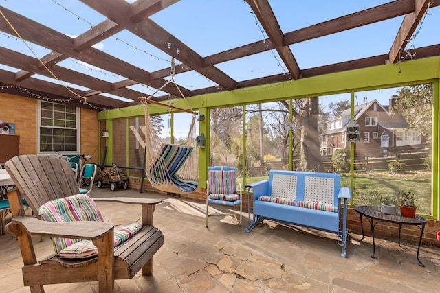 sunroom featuring beamed ceiling and a skylight