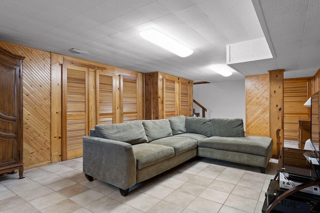 living room featuring stairway and wooden walls