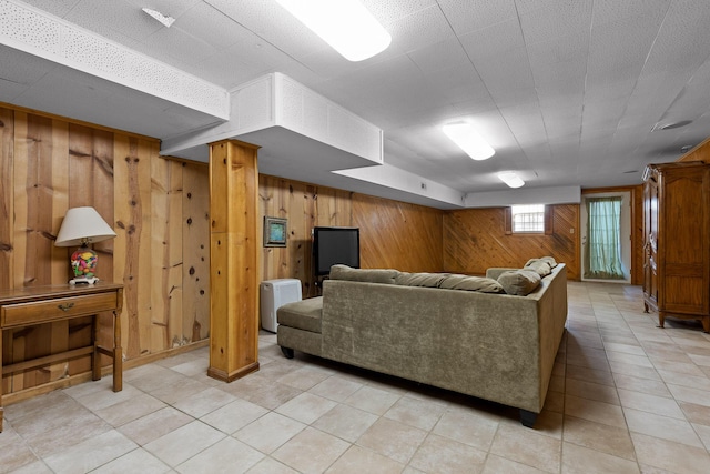 living area with wood walls and light tile patterned flooring