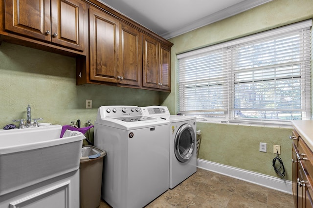 laundry room featuring baseboards, cabinet space, ornamental molding, washer and dryer, and a textured wall