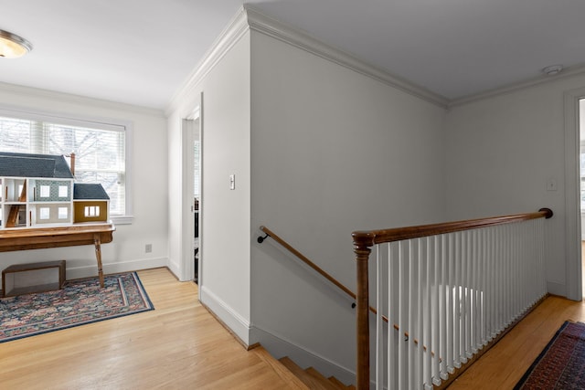 stairs with ornamental molding, baseboards, and wood finished floors