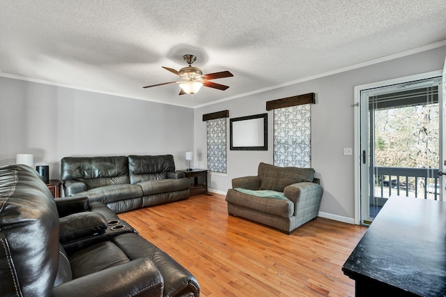 living area with light wood-style flooring, a textured ceiling, crown molding, and a ceiling fan