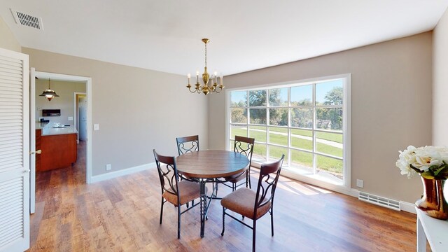 dining room featuring hardwood / wood-style floors and a notable chandelier