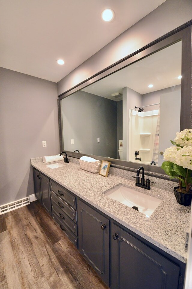 bathroom featuring hardwood / wood-style flooring, vanity, and a shower