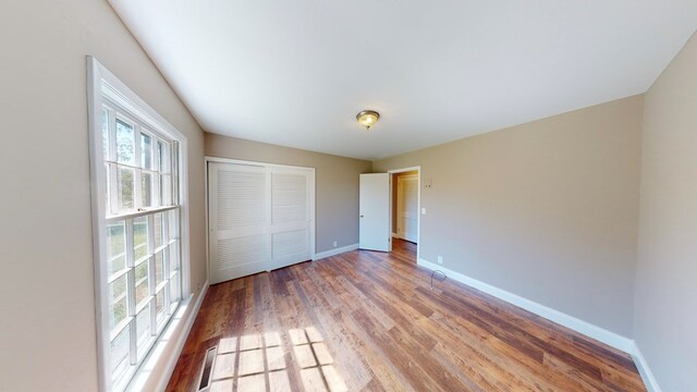 unfurnished bedroom featuring hardwood / wood-style floors and a closet