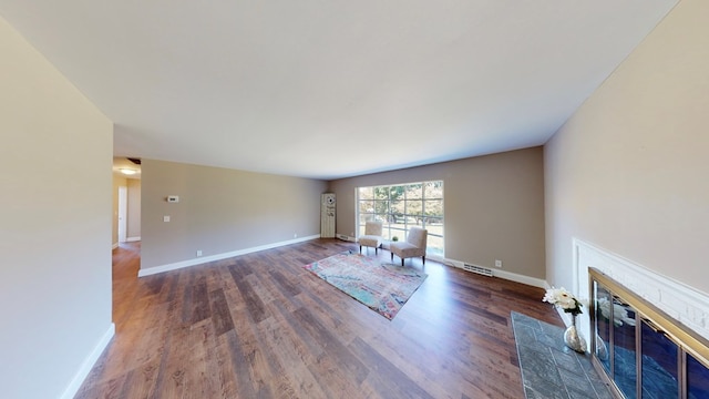 unfurnished living room with dark hardwood / wood-style flooring and a fireplace