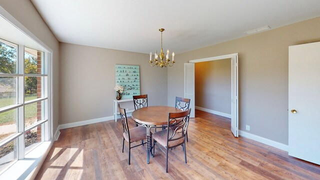 dining room with a notable chandelier and light hardwood / wood-style flooring