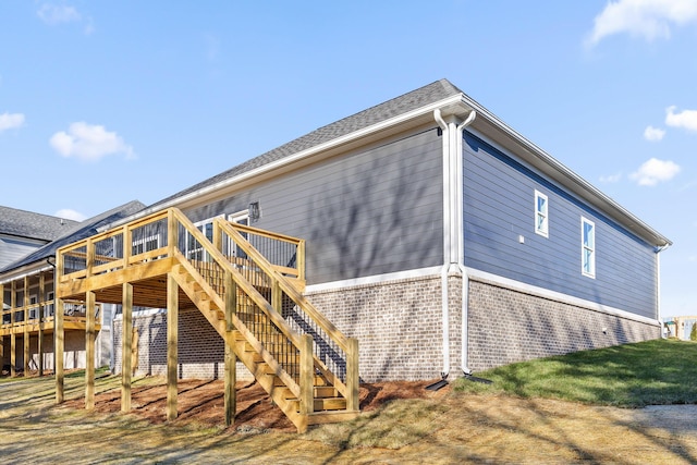 back of house featuring brick siding, stairway, and a wooden deck