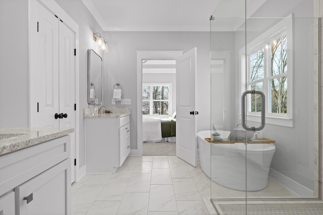 ensuite bathroom featuring a freestanding bath, marble finish floor, ensuite bath, and vanity