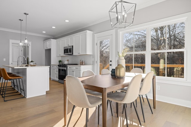 dining space with light wood-style flooring, baseboards, crown molding, and recessed lighting