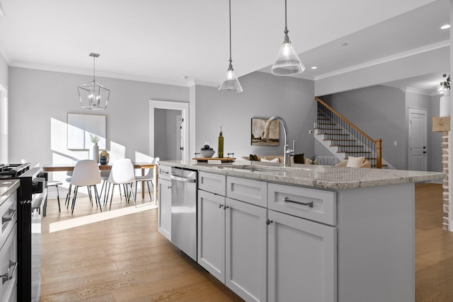 kitchen featuring stainless steel dishwasher, a kitchen island, gas range, and pendant lighting