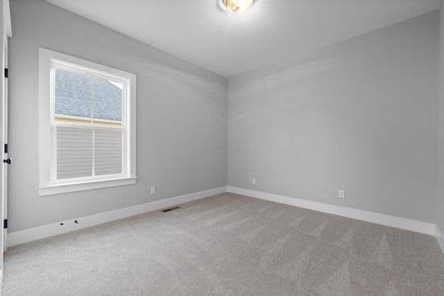 carpeted empty room featuring baseboards and visible vents