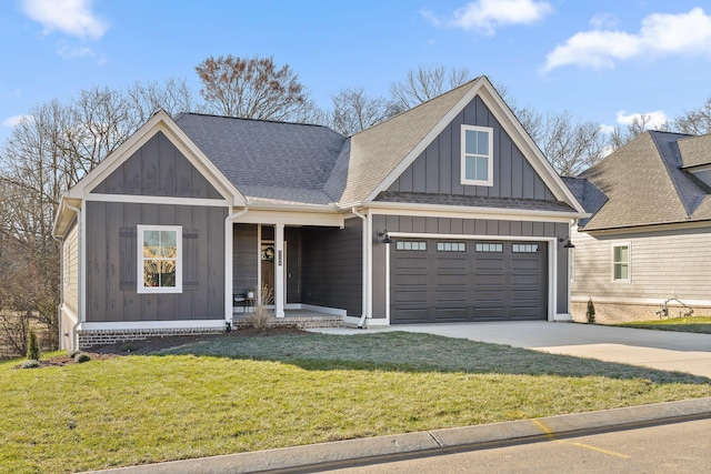 view of front of house with covered porch, concrete driveway, roof with shingles, a front lawn, and board and batten siding