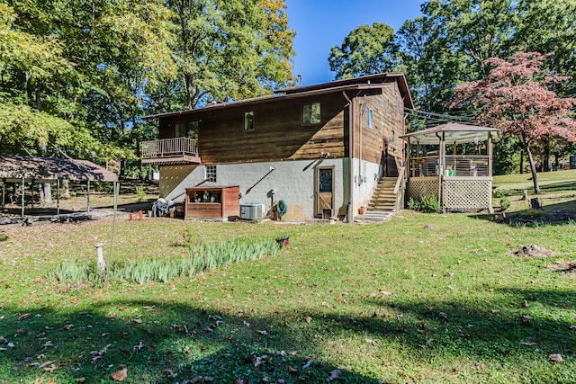 back of house with a gazebo, central air condition unit, and a lawn