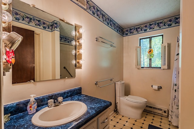 bathroom with a textured ceiling, vanity, toilet, and a baseboard heating unit