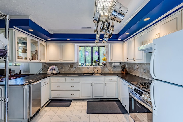 kitchen with white appliances, a raised ceiling, crown molding, sink, and light tile patterned floors