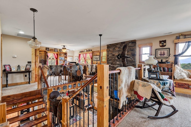 carpeted dining area with ceiling fan and a wood stove