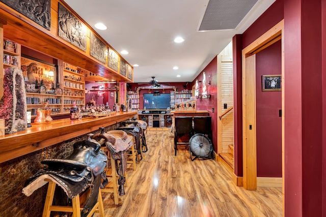 bar featuring light wood-type flooring and ceiling fan