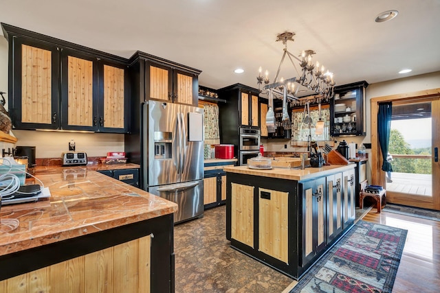 kitchen featuring hanging light fixtures, an inviting chandelier, dark hardwood / wood-style flooring, wooden counters, and appliances with stainless steel finishes