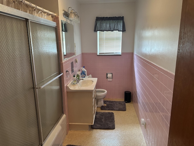 119 Cane Creek Rd, Rocky Top, TN 37769 - full bathroom featuring wainscoting, toilet, tile walls, vanity, and enclosed tub / shower combo