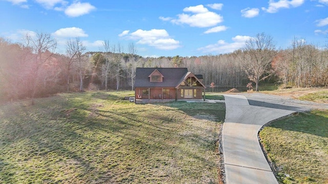 view of front of house with a forest view and a front yard