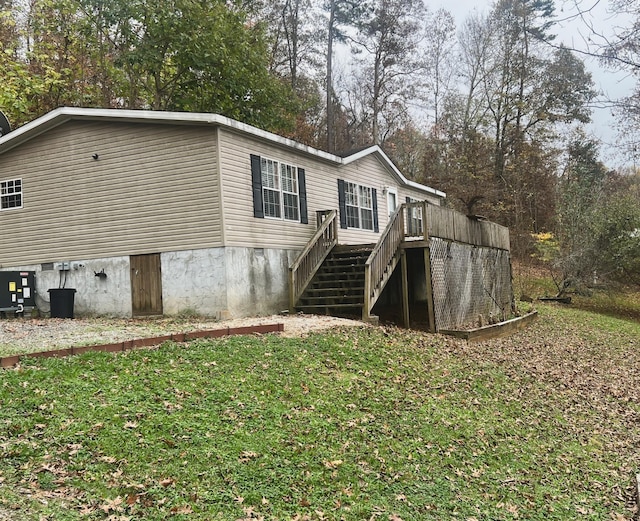 rear view of property featuring a lawn and a wooden deck