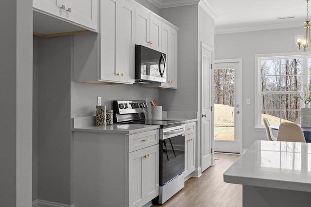 425 Minnis Rd NE Unit 2C, Cleveland, TN 37323 - kitchen with black microwave, stainless steel electric range, light countertops, plenty of natural light, and ornamental molding