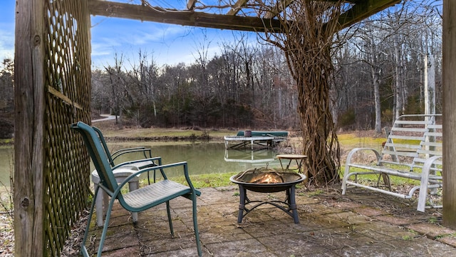 view of patio / terrace featuring a water view and a fire pit